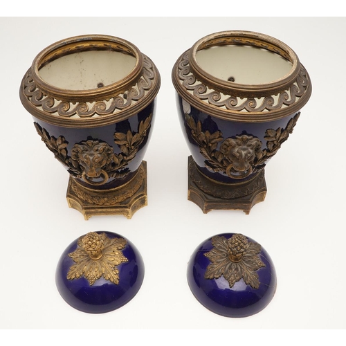 610 - PAIR OF SEVRES STYLE LIDDED PORCELAIN URNS. A pair of porcelain and gilded metal mounted urns,  with... 