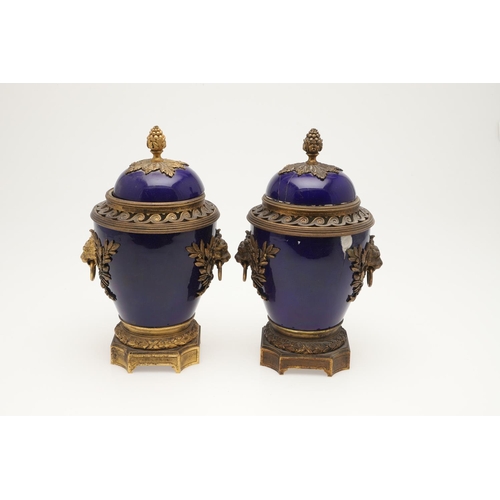 610 - PAIR OF SEVRES STYLE LIDDED PORCELAIN URNS. A pair of porcelain and gilded metal mounted urns,  with... 