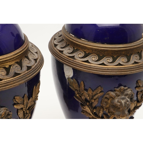 610 - PAIR OF SEVRES STYLE LIDDED PORCELAIN URNS. A pair of porcelain and gilded metal mounted urns,  with... 