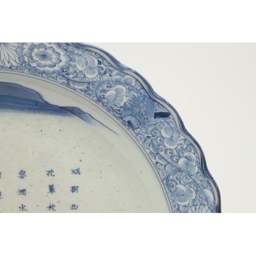 624 - LARGE JAPANESE ARITA DISH. A large blue and white Arita dish, painted with a bridge within a landsca... 