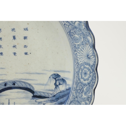 624 - LARGE JAPANESE ARITA DISH. A large blue and white Arita dish, painted with a bridge within a landsca... 