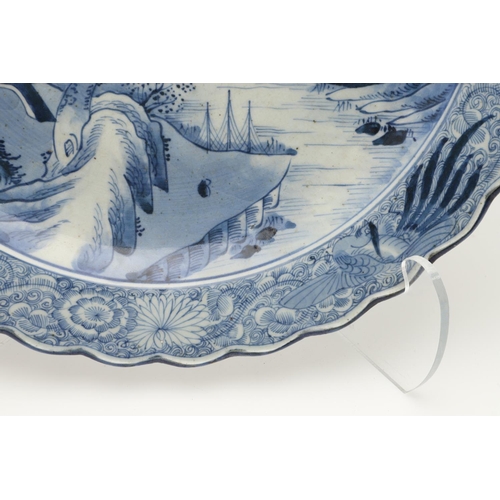 624 - LARGE JAPANESE ARITA DISH. A large blue and white Arita dish, painted with a bridge within a landsca... 