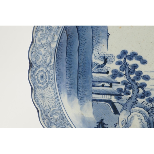 624 - LARGE JAPANESE ARITA DISH. A large blue and white Arita dish, painted with a bridge within a landsca... 