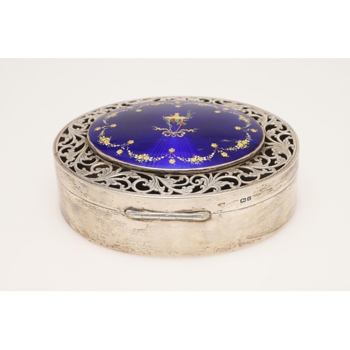 101 - A GEORGE V SILVER & ENAMEL BOX. of oval form, the cover with a pierced scroll border surrounding an ... 