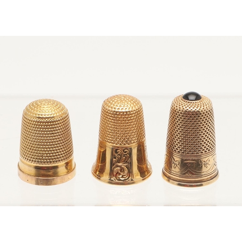 125 - THREE CASED GOLD THIMBLES. one with a panelled body & engraved decoration, one with a plain body and... 