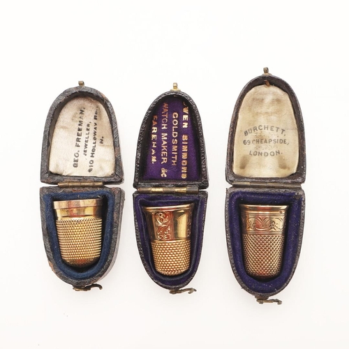 125 - THREE CASED GOLD THIMBLES. one with a panelled body & engraved decoration, one with a plain body and... 