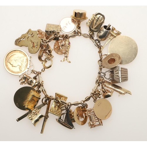 146 - A 9CT GOLD CHARM BRACELET. suspending many assorted gold charms, two silver charms and a gold half s... 