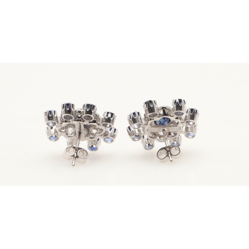 214 - A PAIR OF SAPPHIRE AND DIAMOND CLUSTER EARRINGS. each earring centred with an oval-shaped sapphire w... 