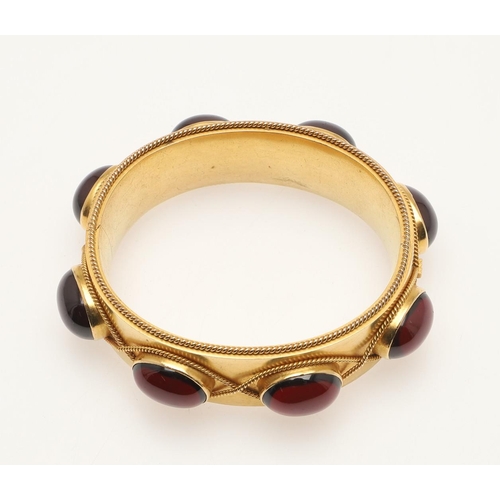 219 - A GEORGIAN GARNET AND GOLD HINGED BANGLE. mounted with oval-shaped cabochon garnets,  with embossed ... 