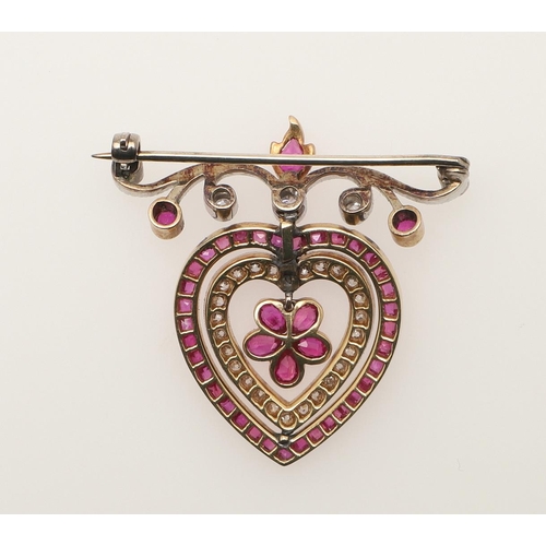 220 - AN EARLY 20TH CENTURY RUBY AND DIAMOND HEART BROOCH. the central ruby set flowerhead is suspended fr... 