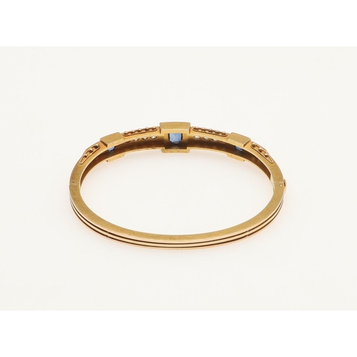 230 - A SAPPHIRE, DIAMOND AND GOLD HALF HINGED BANGLE. mounted to one side with three oval-shaped sapphire... 