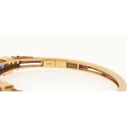 230 - A SAPPHIRE, DIAMOND AND GOLD HALF HINGED BANGLE. mounted to one side with three oval-shaped sapphire... 