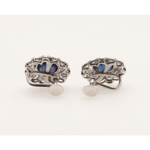 233 - A PAIR OF SAPPHIRE AND DIAMOND CLUSTER EARRINGS. each earring set with an oval-shaped sapphire withi... 