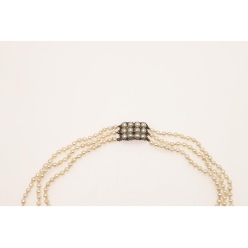 241 - A THREE ROW NATURAL PEARL NECKLACE. the pearls vary in width from 2.8mm to 3.1mm and are set to a Ge... 