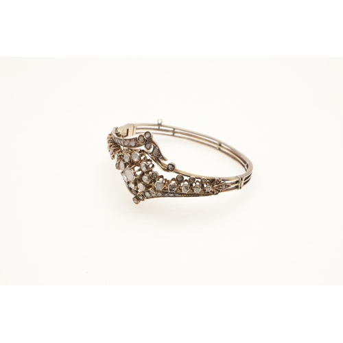 248 - A DIAMOND AND GOLD HALF HINGED BANGLE. the central cluster mounted with rose-cut diamonds and overal... 