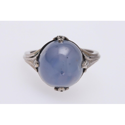 267 - A STAR SAPPHIRE AND DIAMOND RING. the cabochon sapphire is set with four circular-cut diamonds in wh... 