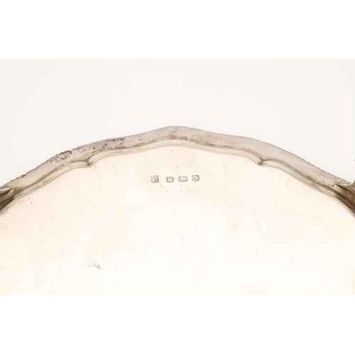 41 - A GEORGE VI SILVER SALVER. of shaped circular outline, with a gadrooned border, ball & claw legs and... 