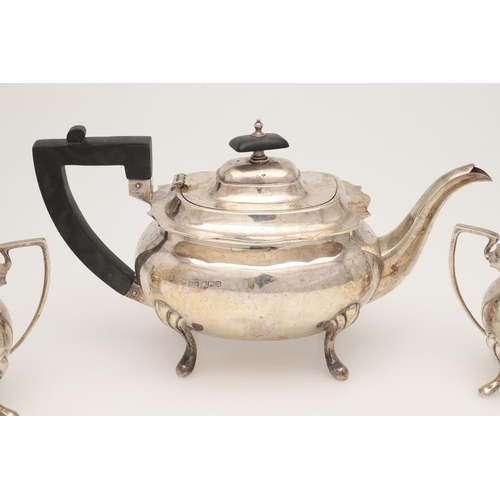 42 - AN EARLY 20TH CENTURY THREE-PIECE SILVER TEA SET. with rounded rectangular bodies, angular handles a... 