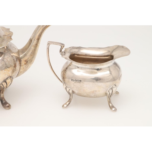 42 - AN EARLY 20TH CENTURY THREE-PIECE SILVER TEA SET. with rounded rectangular bodies, angular handles a... 