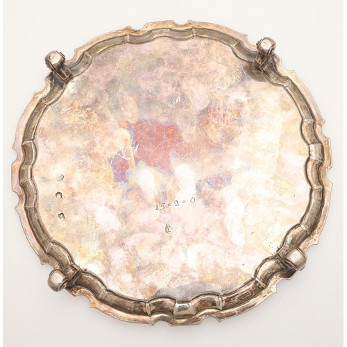 44 - A GEORGE II SMALL SILVER SALVER. of shaped circular outline, with a moulded border and on four scrol... 