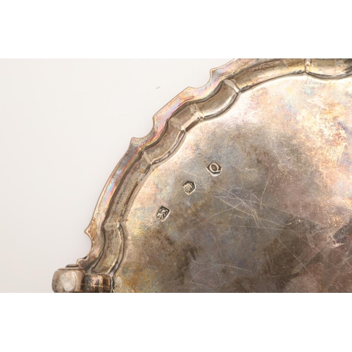 44 - A GEORGE II SMALL SILVER SALVER. of shaped circular outline, with a moulded border and on four scrol... 