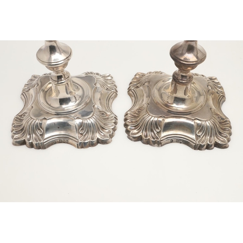 54 - A SET OF FOUR LATE VICTORIAN SILVER CANDLESTICKS. on shaped square bases (loaded), with knopped stem... 