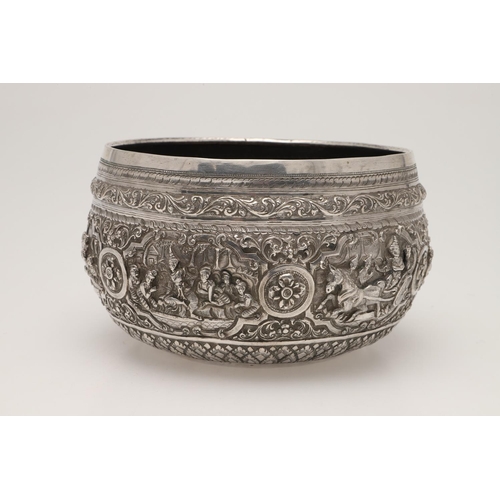 57 - A LATE 19TH/ EARLY 20TH CENTURY BURMESE SILVER RICE BOWL. embossed and chased around the sides in re... 