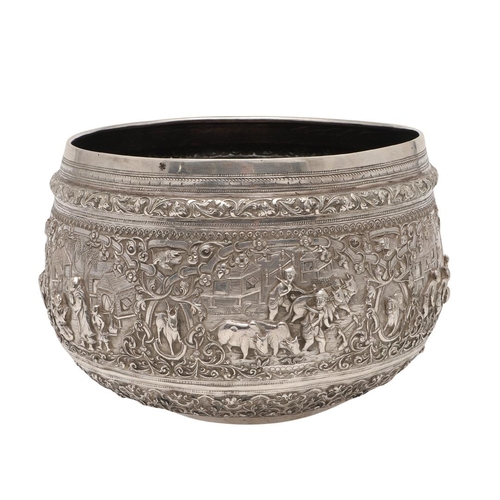 58 - A LATE 19TH/ EARLY 20TH CENTURY BURMESE SILVER RICE BOWL. embossed and chased around the sides in re... 