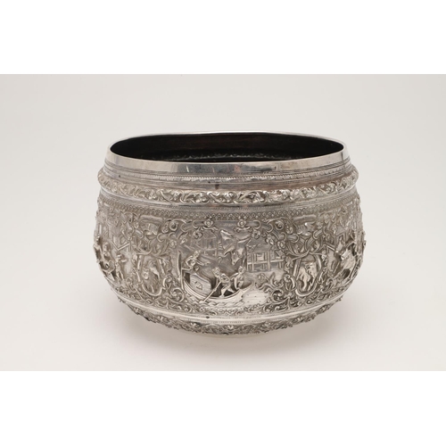 58 - A LATE 19TH/ EARLY 20TH CENTURY BURMESE SILVER RICE BOWL. embossed and chased around the sides in re... 