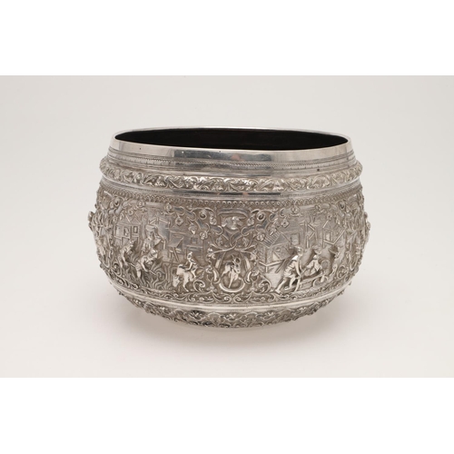 58 - A LATE 19TH/ EARLY 20TH CENTURY BURMESE SILVER RICE BOWL. embossed and chased around the sides in re... 