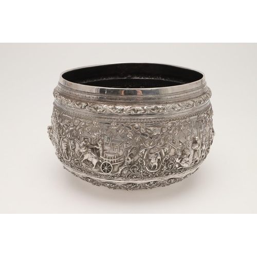 58 - A LATE 19TH/ EARLY 20TH CENTURY BURMESE SILVER RICE BOWL. embossed and chased around the sides in re... 