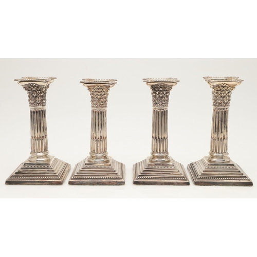 65 - TWO PAIRS OF LATE VICTORIAN SILVER CANDLESTICKS. with bead borders, fluted columns and on stepped sq... 