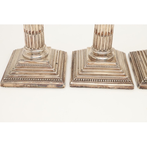 65 - TWO PAIRS OF LATE VICTORIAN SILVER CANDLESTICKS. with bead borders, fluted columns and on stepped sq... 