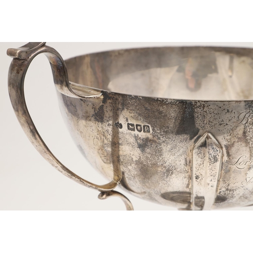 71 - A GEORGE V TWO-HANDLED SILVER CUP. of circular form, the bowl with applied bands, scroll handles and... 