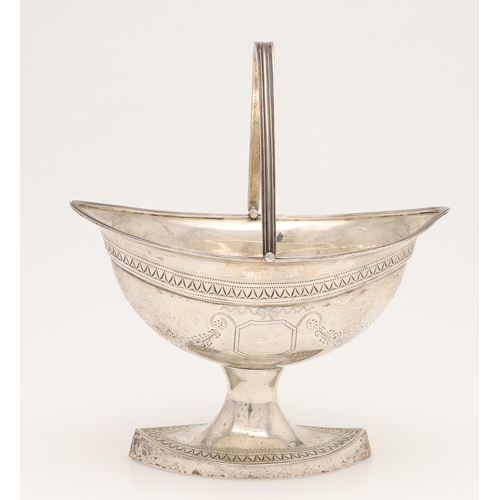 85 - A GEORGE III IRISH SILVER SWING-HANDLE SUGAR BASKET. of navette form, with reeded borders, engraved ... 