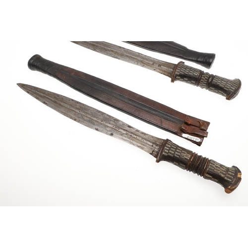 108 - A NEAR IDENTICAL PAIR OF SUDANESE KNIVES AND SCABBARDS. The two blades 32 cm and 30 cm, with curved ... 