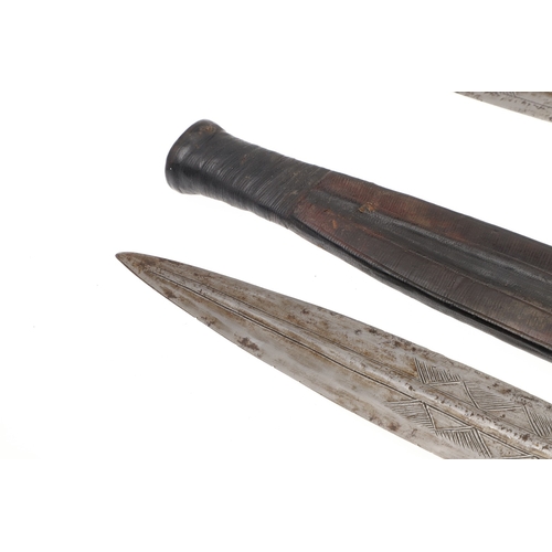 108 - A NEAR IDENTICAL PAIR OF SUDANESE KNIVES AND SCABBARDS. The two blades 32 cm and 30 cm, with curved ... 