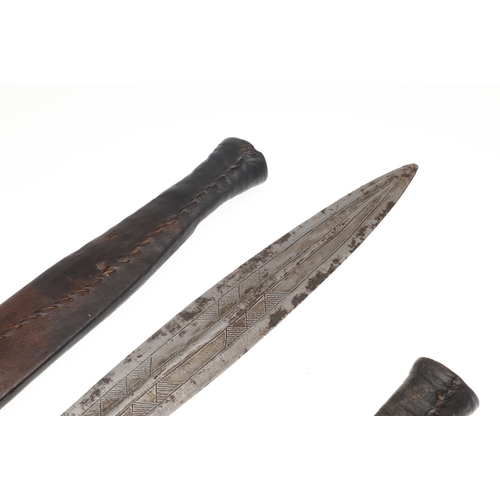 108 - A NEAR IDENTICAL PAIR OF SUDANESE KNIVES AND SCABBARDS. The two blades 32 cm and 30 cm, with curved ... 