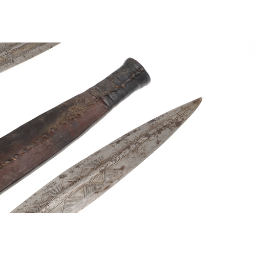 108 - A NEAR IDENTICAL PAIR OF SUDANESE KNIVES AND SCABBARDS. The two blades 32 cm and 30 cm, with curved ... 