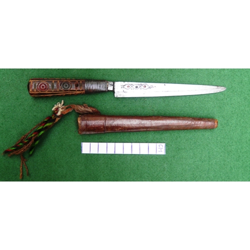 117 - A SOUTH ALGERIAN BOU SADDI KNIFE AND SCABBARD. The 13.5 cm pointed blade with red dot decoration, on... 