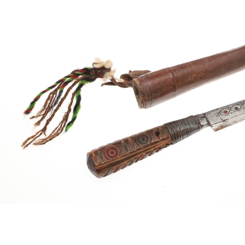 117 - A SOUTH ALGERIAN BOU SADDI KNIFE AND SCABBARD. The 13.5 cm pointed blade with red dot decoration, on... 