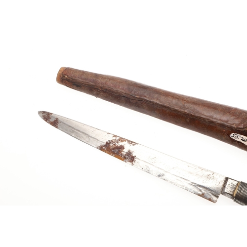 117 - A SOUTH ALGERIAN BOU SADDI KNIFE AND SCABBARD. The 13.5 cm pointed blade with red dot decoration, on... 