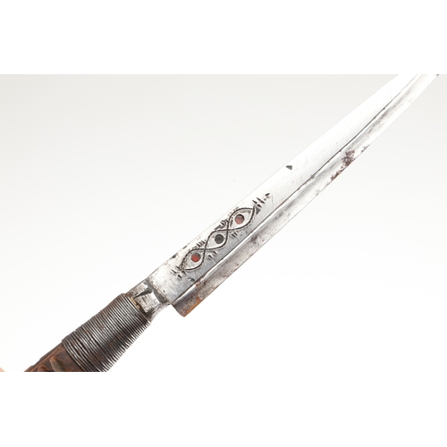 117 - A SOUTH ALGERIAN BOU SADDI KNIFE AND SCABBARD. The 13.5 cm pointed blade with red dot decoration, on... 