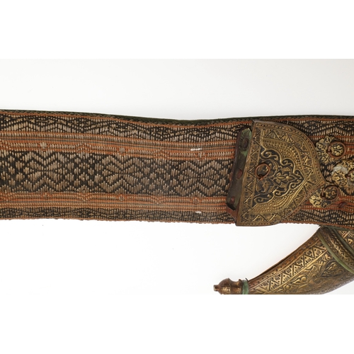 63 - A YEMENI JANABI KNIFE AND SCABBARD ON THE ORIGINAL BROAD BELT. The knife with a 22 cm curved blade w... 
