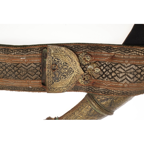 63 - A YEMENI JANABI KNIFE AND SCABBARD ON THE ORIGINAL BROAD BELT. The knife with a 22 cm curved blade w... 