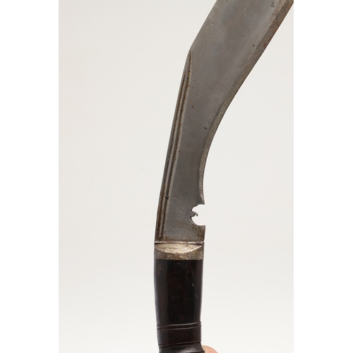 69 - A KUKRI KNIFE AND SCABBARD. With a traditionally shaped 25 cm pointed blade on a hardwood handle. In... 