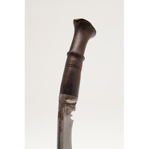 69 - A KUKRI KNIFE AND SCABBARD. With a traditionally shaped 25 cm pointed blade on a hardwood handle. In... 
