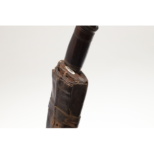 69 - A KUKRI KNIFE AND SCABBARD. With a traditionally shaped 25 cm pointed blade on a hardwood handle. In... 