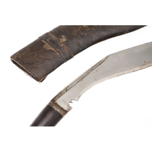 69 - A KUKRI KNIFE AND SCABBARD. With a traditionally shaped 25 cm pointed blade on a hardwood handle. In... 