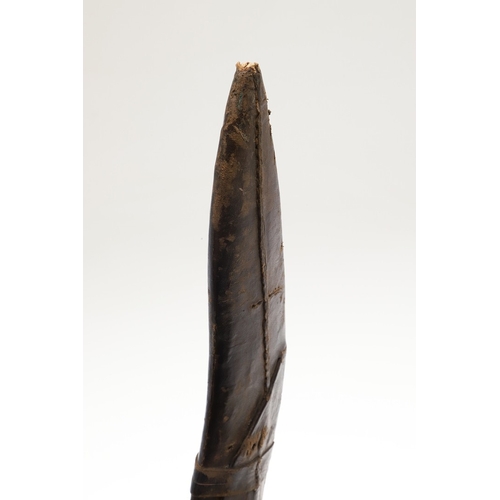 69 - A KUKRI KNIFE AND SCABBARD. With a traditionally shaped 25 cm pointed blade on a hardwood handle. In... 